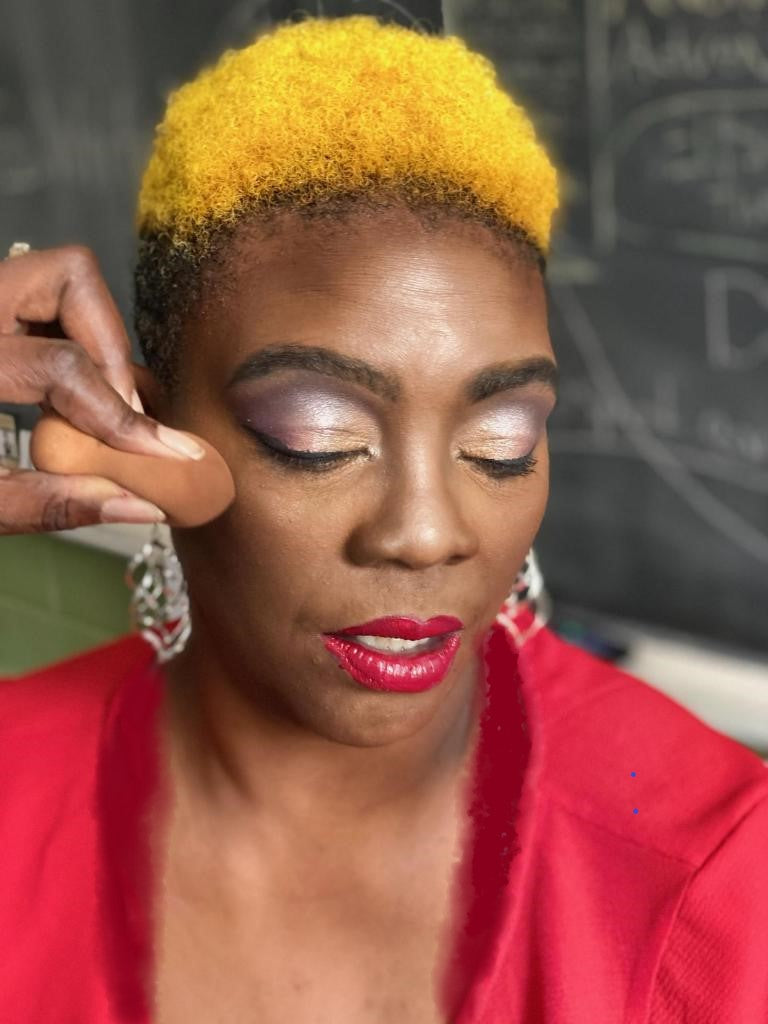 Black woman getting makeup applied